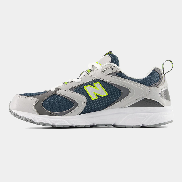 New Balance 408 sneakers in gray and navy with mesh upper, leather accents, neon green logo detail, and white outsole, side view.