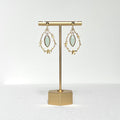 This earring set features a gold branch &amp; flower hoop in which hangs a minty green glass marquise shaped bezel set charm, hung on a gold filled 4mm ball stud earring post.&nbsp;