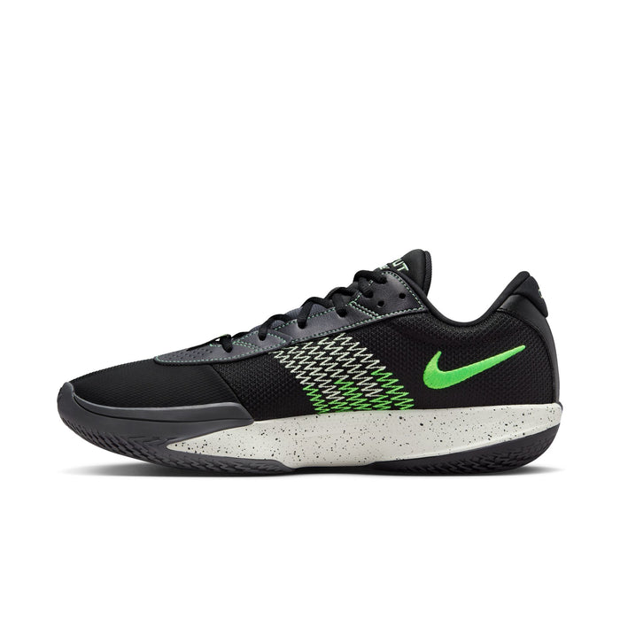 Nike Air Zoom G.T. Cut Academy basketball shoes in black with green swoosh logo, zigzag accents, and speckled white midsole, side view.