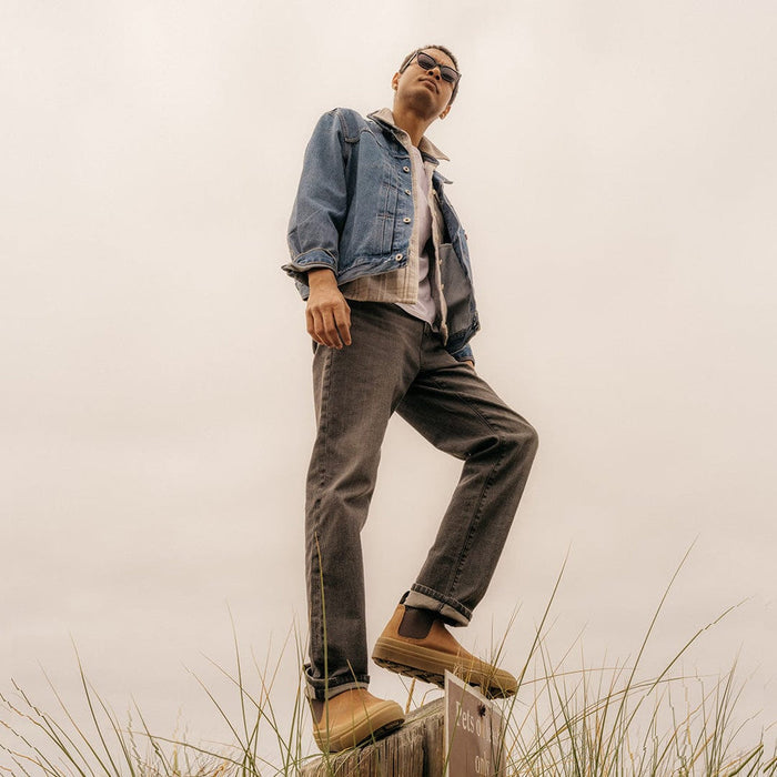 SeaVees Ballard Boot in tan with minimalist design and sturdy construction, worn outdoors on a wooden post for lifestyle context