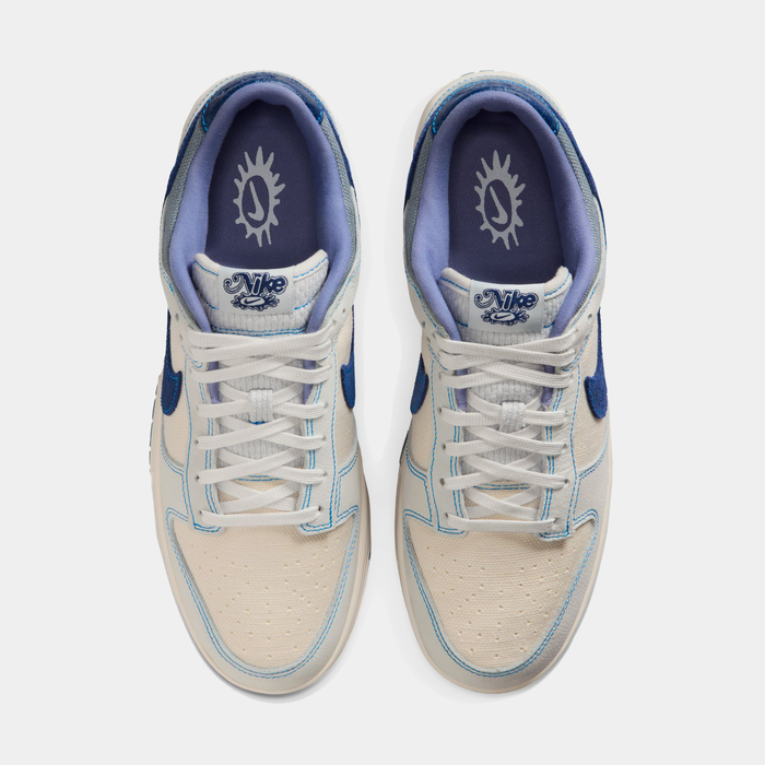 Nike Dunk Low Retro SE sneakers in white and blue with perforated toe box, embroidered branding, and padded collar, top view.