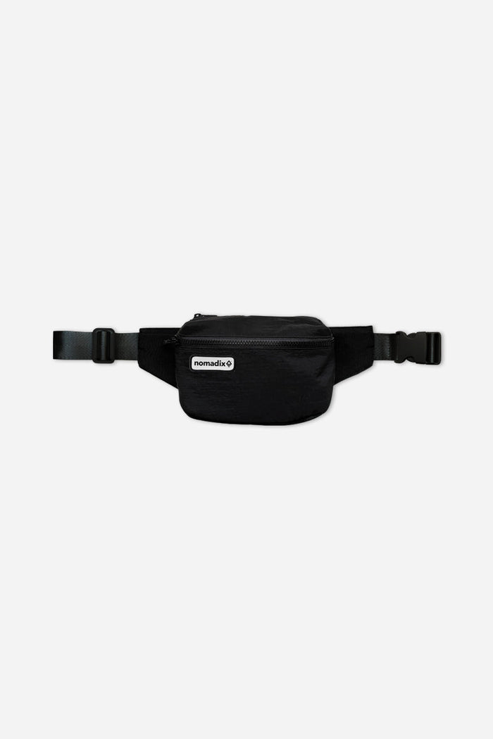 Nomadix Fanny Pack in black featuring a zippered main compartment, adjustable strap, and buckle closure, front view.