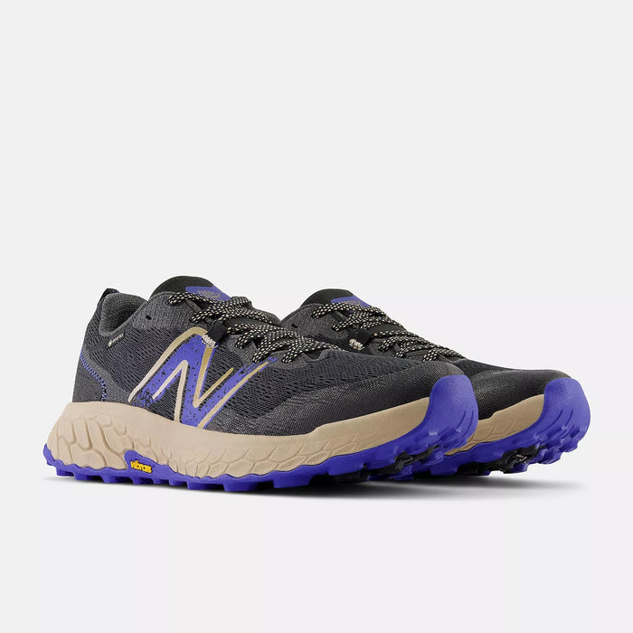 New Balance Fresh Foam X Hierro v7 Gore-Tex trail running shoes in gray with purple and beige accents, front angled view showing Vibram outsole and rugged design.