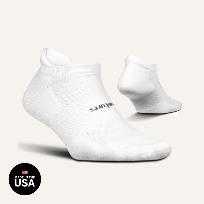 Feetures High Performance Max Cushion No Show Tab socks in white with moisture-wicking fabric and cushioned sole, side and angled view.