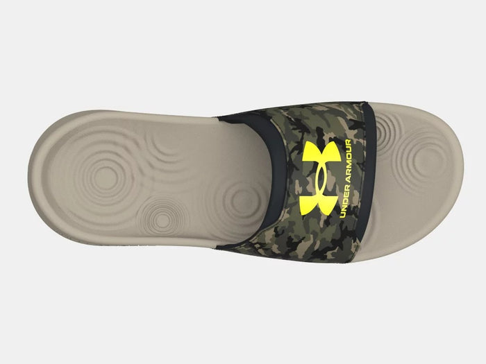 Under Armour Ignite Select Camo slide sandal in tan with camouflage strap featuring yellow Under Armour logo, top view.