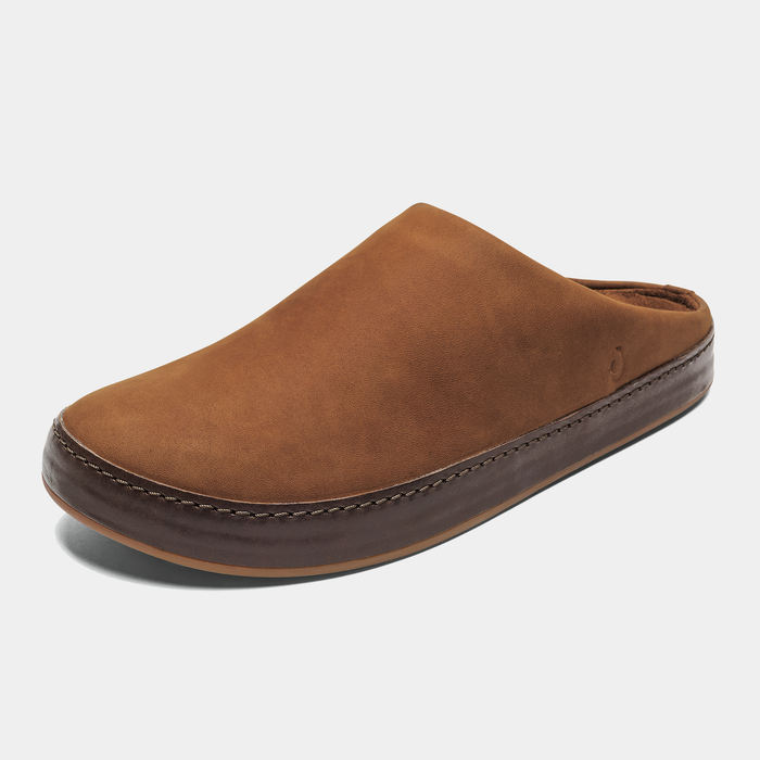 OluKai Ku'u slip-on shoes in rich brown leather with contrasting stitched midsole, angled front and side view.