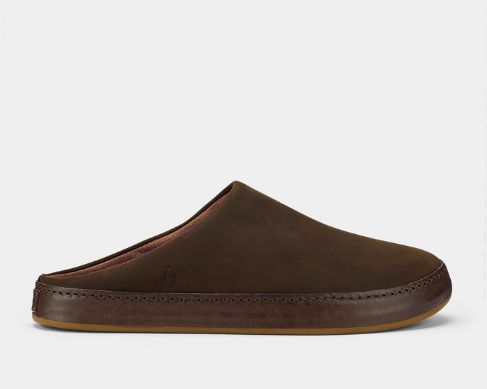 OluKai Ku'u slippers in rich brown leather with stitched detailing and cushioned sole, side view.