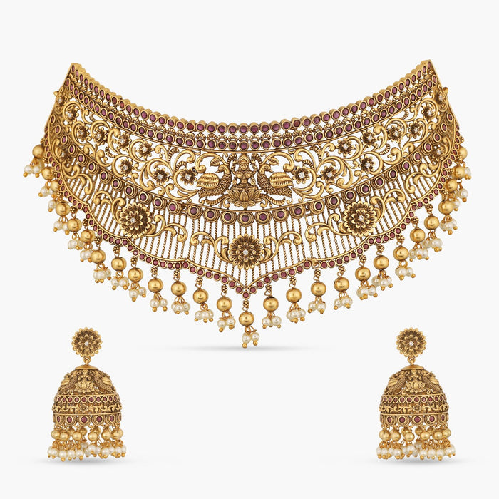 A picture of an Indian antique gold plated necklace set with a Lakshmi idol in the centre and matching earrings.