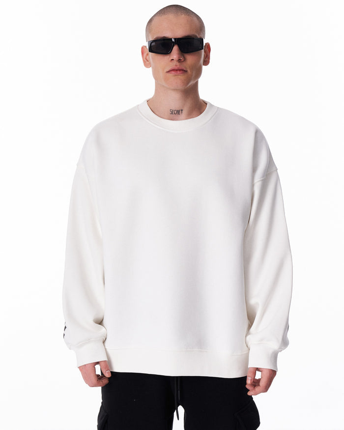 Martin Valen men's white oversized sweatshirt, mid-front view showing roomy fit, ribbed cuffs and vertical black sleeve lettering