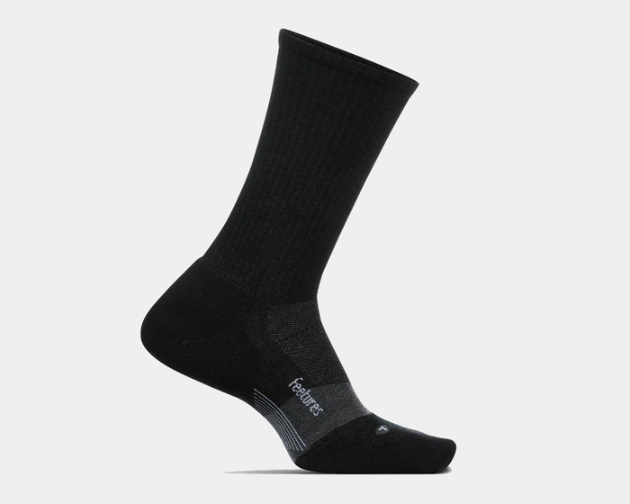 Feetures Merino 10 Max Cushion Crew socks in black featuring ribbed upper and reinforced cushioning, side view.
