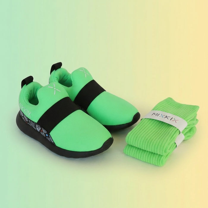 Pair of neon green shoes with black soles and matching socks on a gradient background