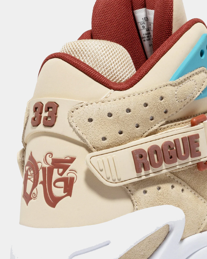 "Ewing Athletics ROGUE x ICE T sneakers in beige suede with red accents, embroidered details, and velcro strap, close-up side view"