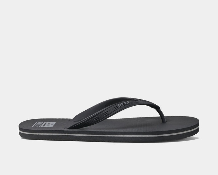 Reef Seaside sandals in black with textured strap and cushioned footbed, side view.